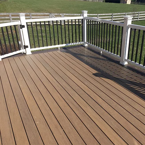 Custom composite deck with white posts, black aluminum railing, and brown composite decking